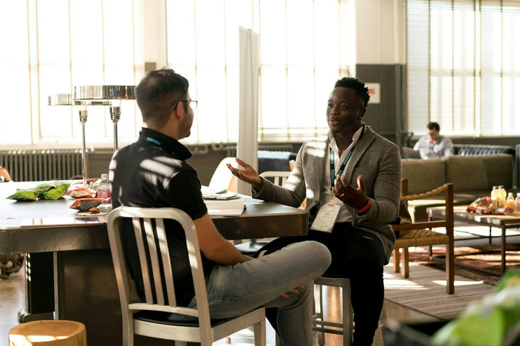 Two people sitting at a business meeting, smiling.